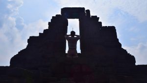 Orang beribadah membawa dupa di Candi Jago — Sejarah Candi Jago Malang dan aktivitas spiritual.