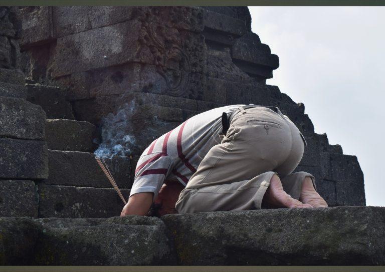 Pengunjung bersembahyang membawa dupa di area Candi Jago