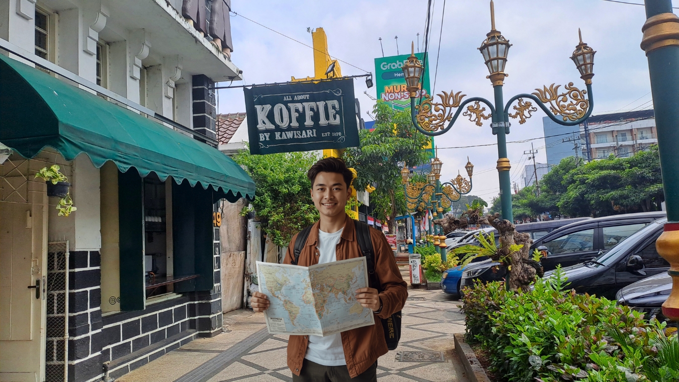 Wisatawan merencanakan itinerary Malang dengan melihat peta di kawasan heritage