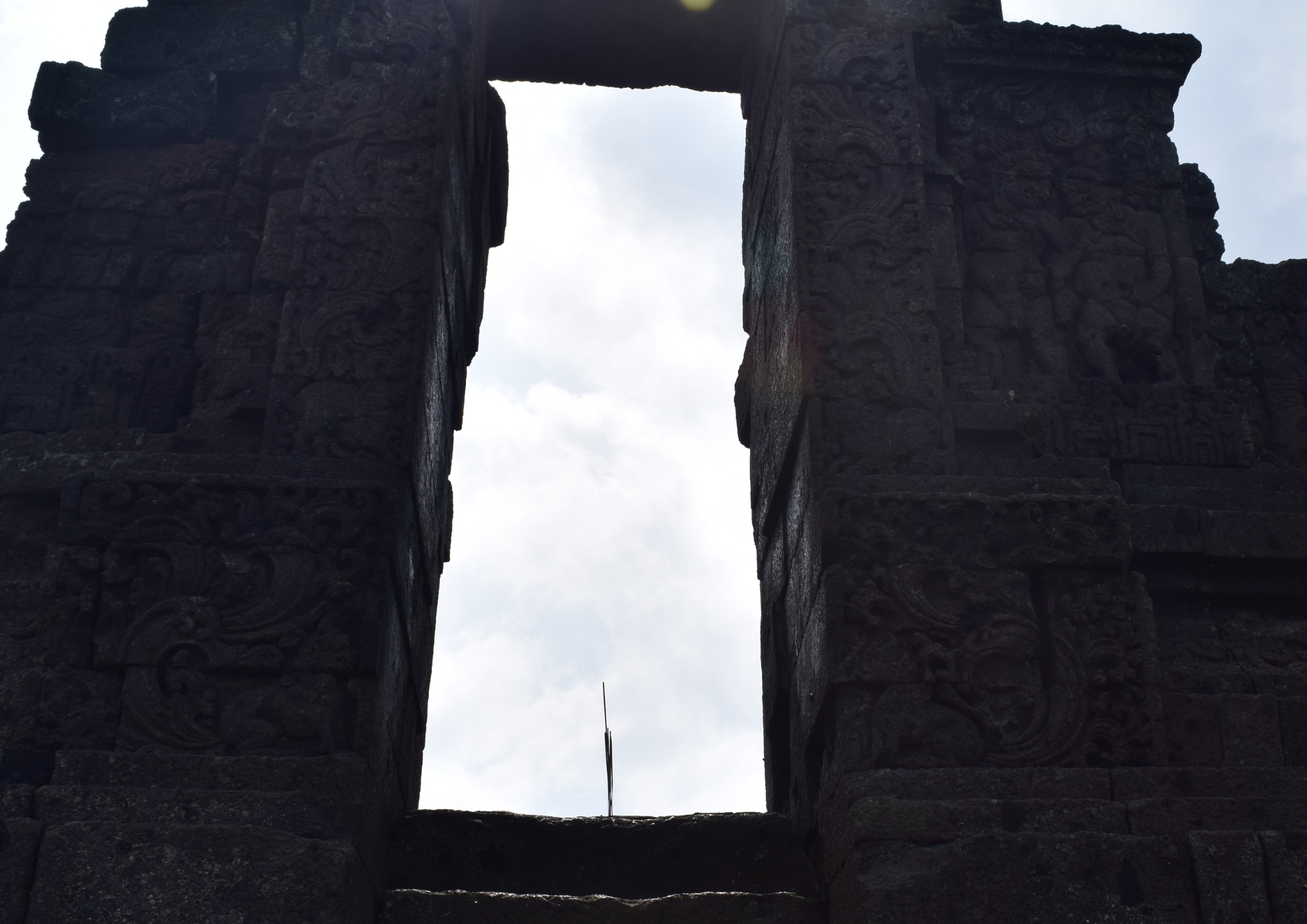Dupa terpasang di depan pintu Candi Jago Malang dengan latar batu candi kuno