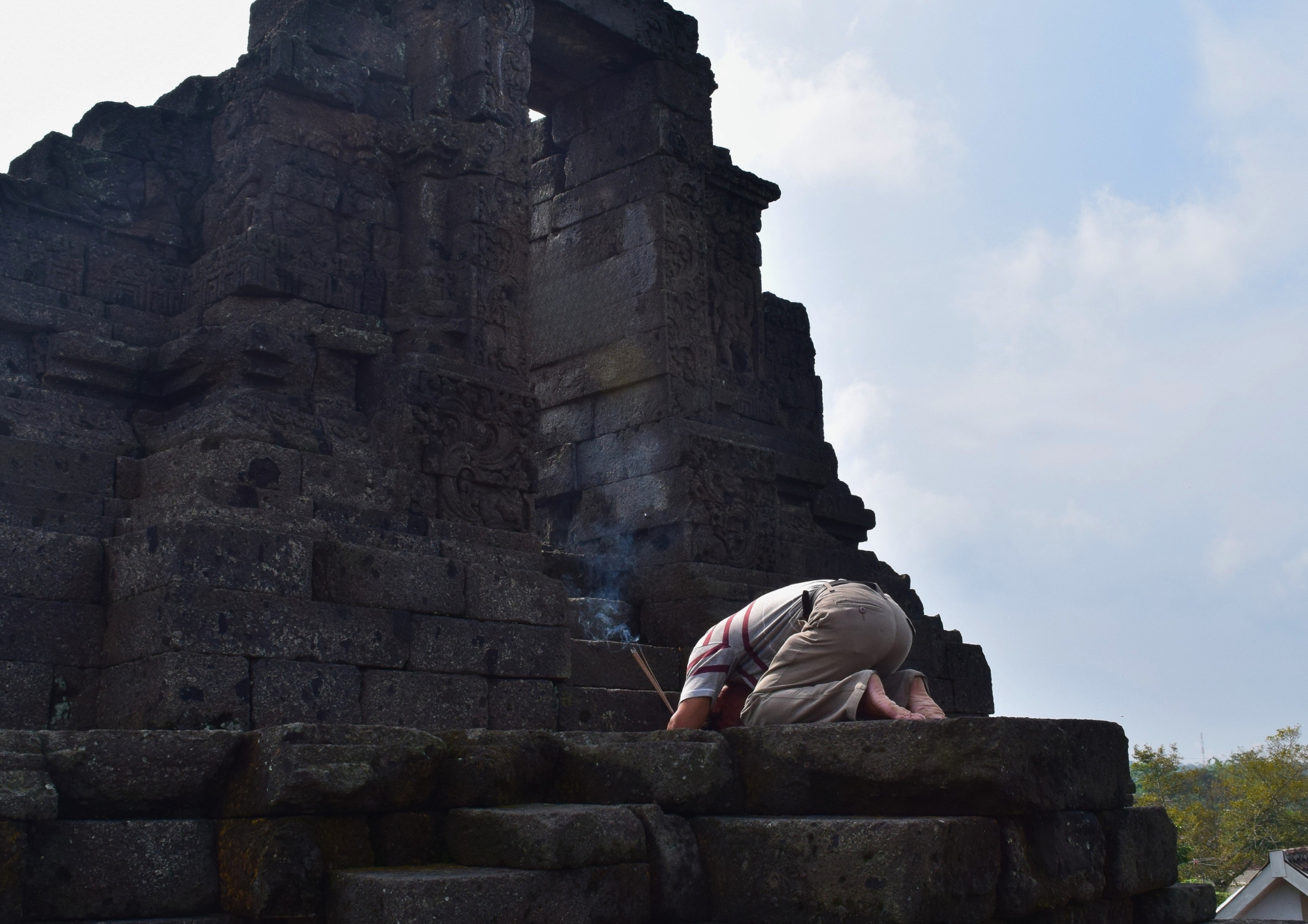 Pengunjung membawa dupa sambil berdoa di depan pintu Candi Jago Malang