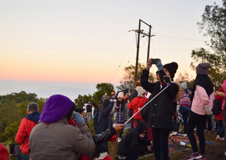 wisatawan sedang berfoto di love hill bromo saat sunrise