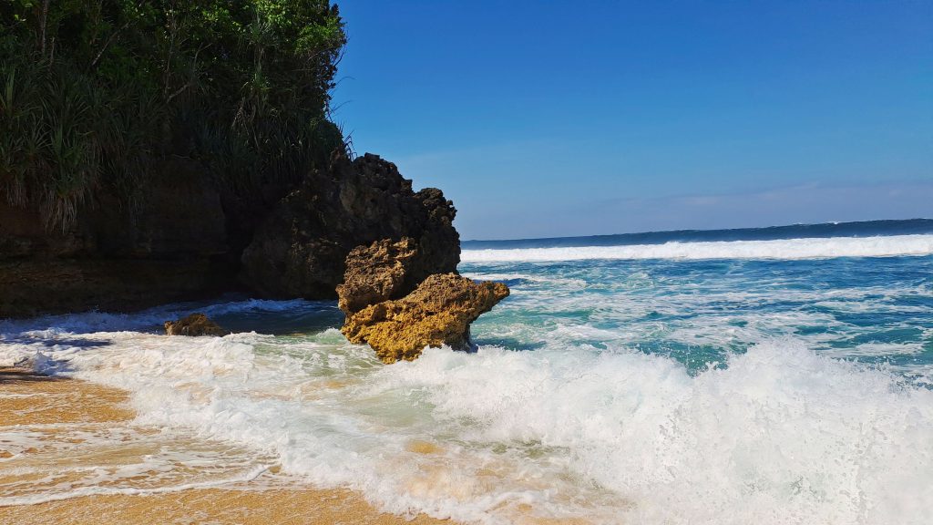 Pemandangan Pantai Selok Malang dengan karang di tengah laut